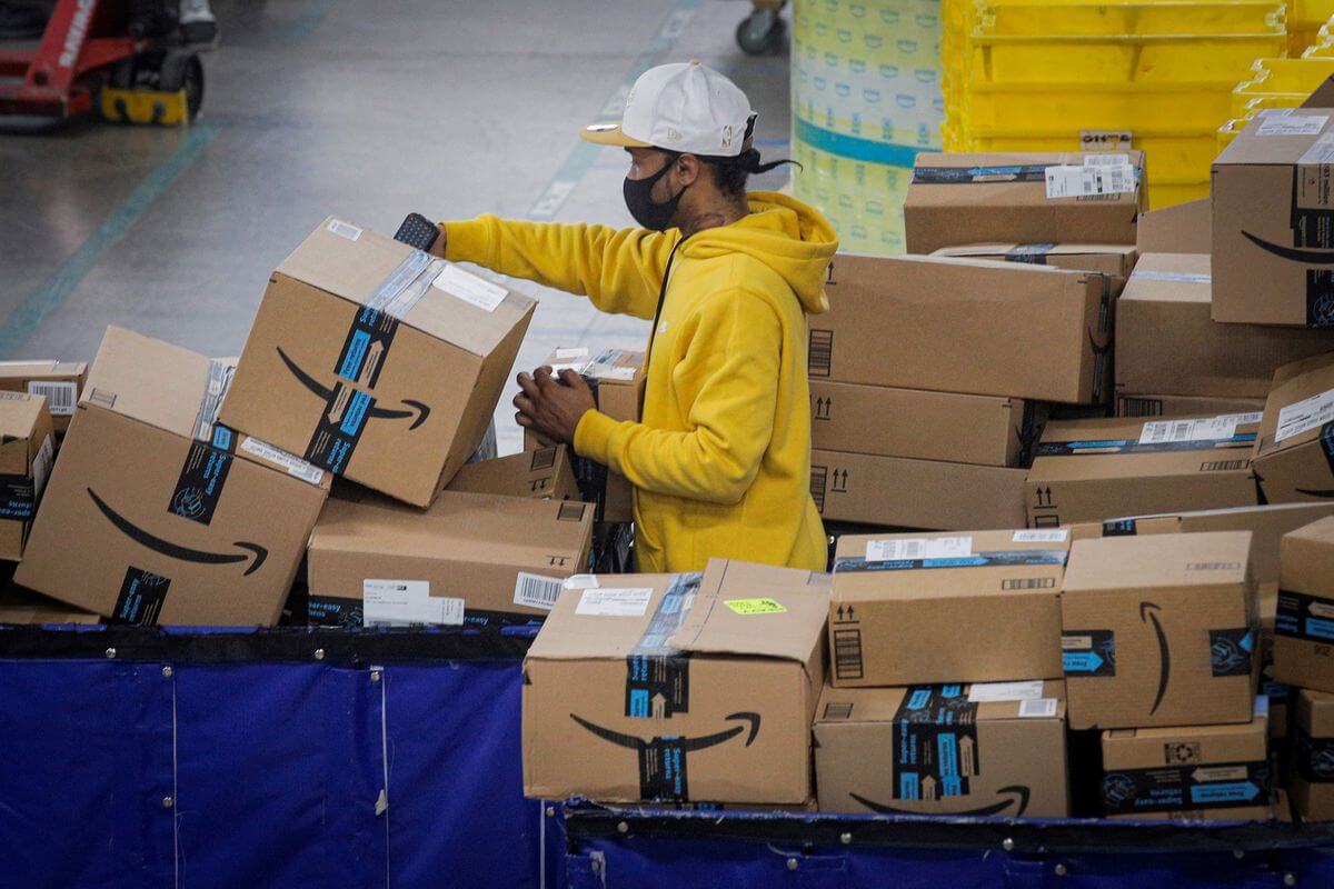 Amazon warehouse worker moving a box from one place to another