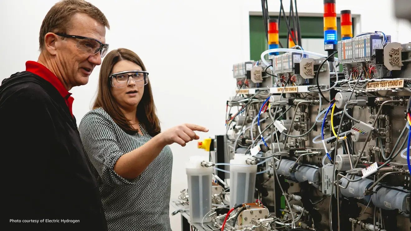 Woman pointing out a machine while explaining it to a colleague